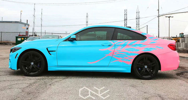 masina bleu deschis lucios cu un logo roz intr-o parcare