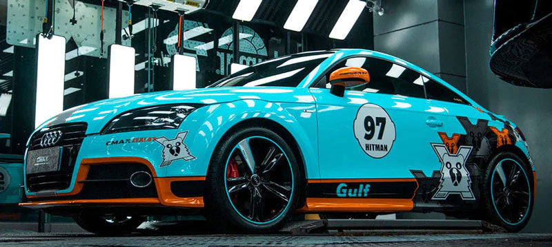 masina sport bleu deschis lucios cu desene intr-un atelier