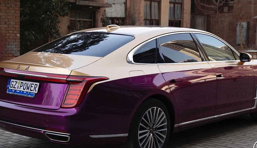 masina cu partea superioara aurie parcata in fata unei cladiri