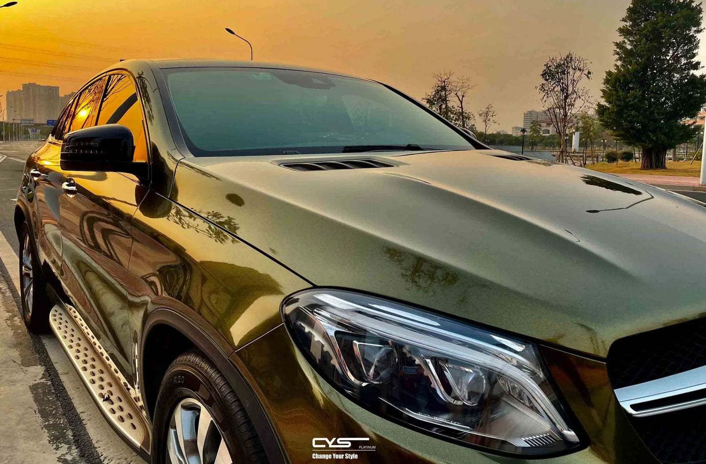 masina auriu inchis parcata pe o parte a strazii