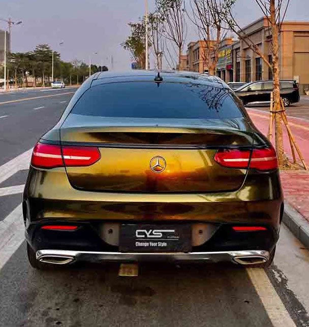 masina auriu inchis parcata pe o parte a strazii