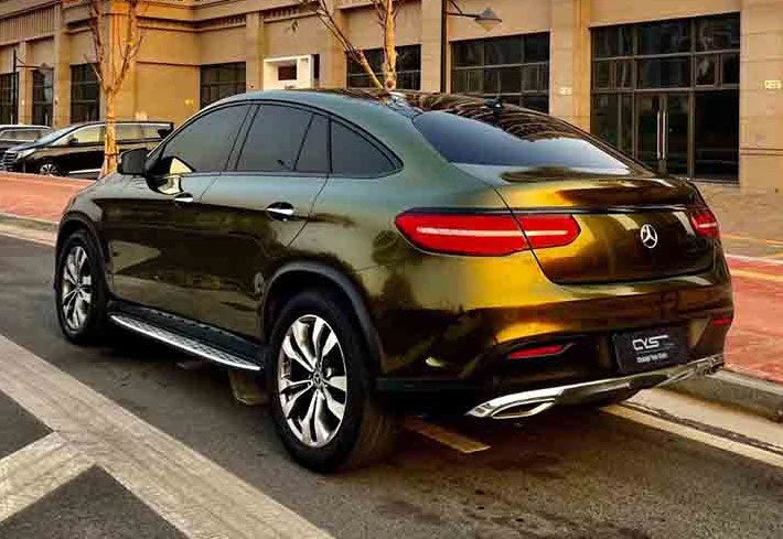 masina auriu inchis parcata pe o parte a strazii