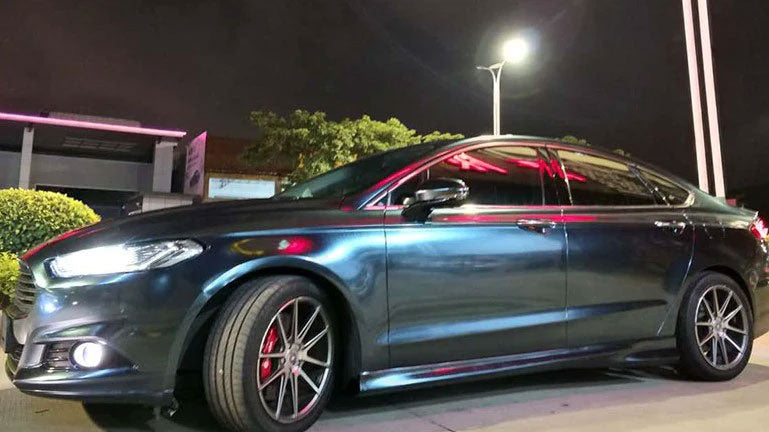 masina albastru inchis metalizat parcata pe marginea strazii