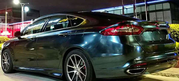 masina albastru inchis metalizat parcata pe marginea strazii