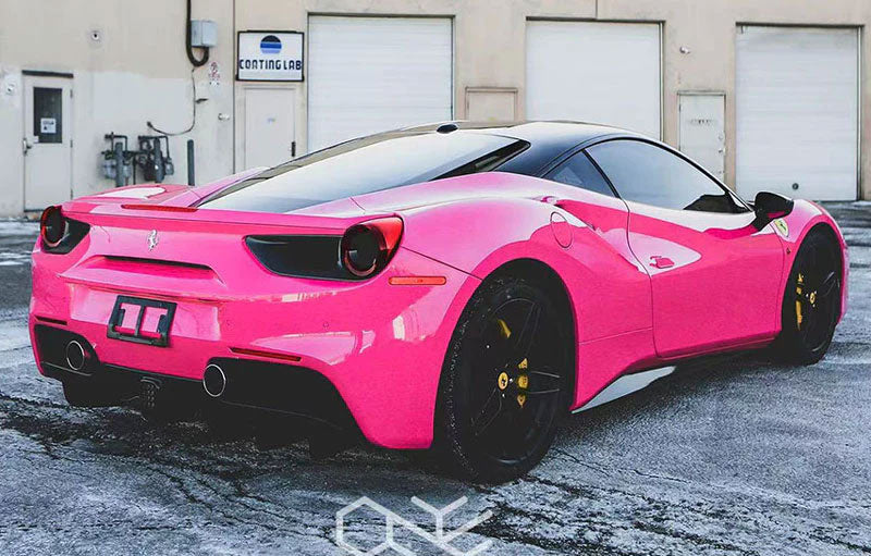 masina sport roz lucios parcata langa usa unui garaj