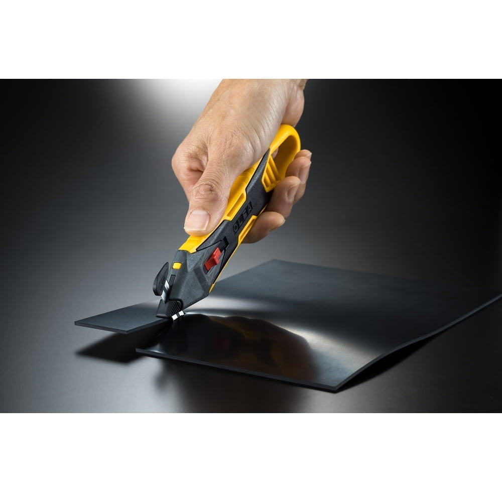 mana cu un cutter galben cu cap de taiere schimbabil negru  taie o bucata de plastic