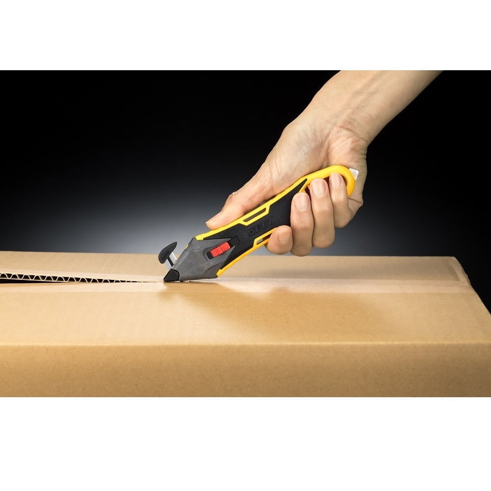 mana cu un cutter galben cu cap de taiere schimbabil negru taie o cutie