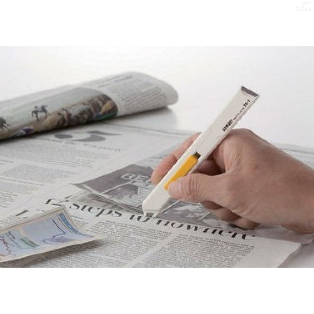 persoana care taie cu un cutter alb cu lama acoperita un ziar