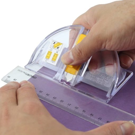 persoana care tine o rigla si un cutter