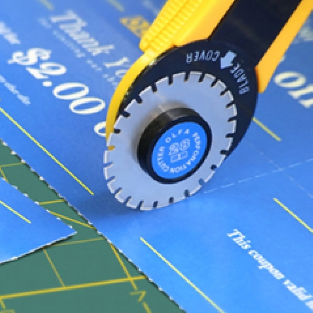 un cutter galben cu lama circulara cu perforatii taie un carton