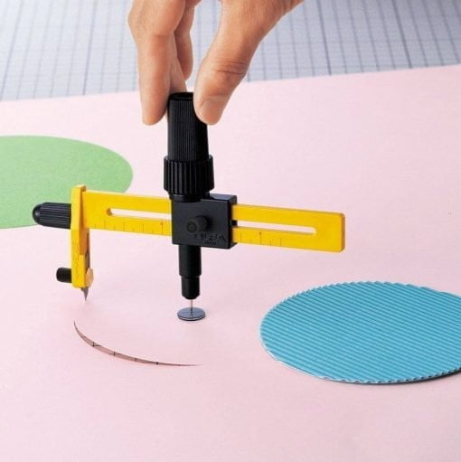 mana care taie un cerc cu ajutorul unui cutter galben cu negru