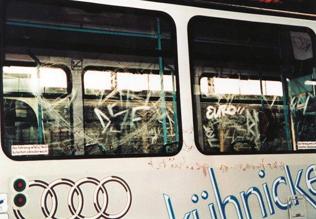 autobuz de transport public acoperit cu graffiti, cu geamuri zgariate si litere si simboluri pictate in exterior. Autobuzul are o sigla Audi pe lateral.