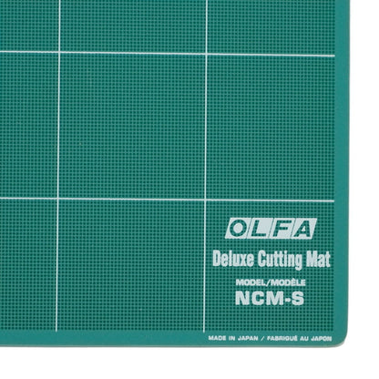 coltul unui dreptunghi verde cu grid gri  inscriptionat OLFA